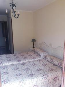 里瓦德塞利亚Casa Rural La Llosica的一间卧室配有一张带花卉床罩的大床