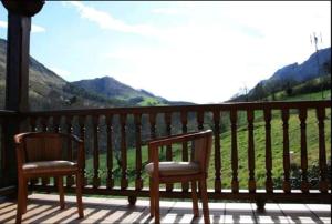 里瓦德塞利亚Casa Rural La Llosica的门廊上的两把椅子,享有山景