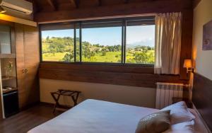 科里奥卡瑟纳德阿巴米亚酒店的一间卧室设有一张床和一个大窗户