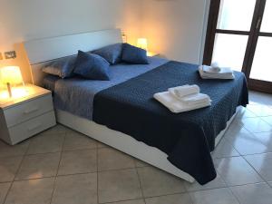 圣贝内代托-德尔特龙托Casavacanze estate 2的一间卧室配有一张床,上面有两条毛巾