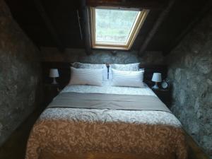 GavilanesCasa rural La Borriquita的一间卧室设有一张大床和窗户