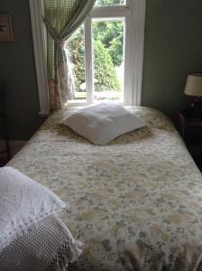 Saint-Luc-de-Vincennes姐妹别墅旅馆的窗户前带枕头的床
