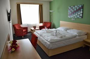 沃拉里波比克梅斯茨基酒店的一间卧室配有一张床、两把椅子和一张桌子