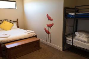 Bow Hill141 Providence Drive, Bowhill的卧室配有两张双层床,墙上挂着红色鲜花