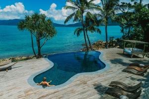 长岛Elysian Luxury Eco Island Retreat的躺在海边游泳池里的人