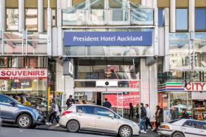奥克兰President Hotel Auckland的停在大楼前的一组汽车