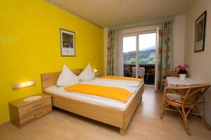 塞博登Landhaus Gastein的一间卧室配有一张床、一张桌子和一个窗户。