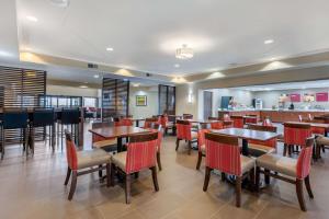 拉法叶Comfort Suites Lafayette University Area的一间带桌椅的餐厅和一间酒吧