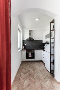 马里博尔Apartment Gondola的厨房铺有木地板,配有白色橱柜。