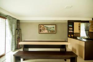 巴东OYO 882 Puri Gevana Guest House的客厅配有长凳和桌子