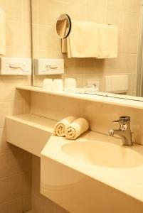 耶岑斯Hotel Garni Romantica的浴室配有盥洗盆、镜子和毛巾