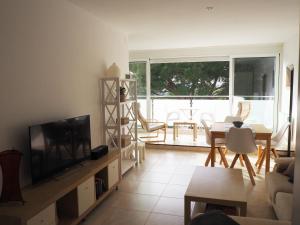 普拉加德阿罗Kaminias II Apartament per 4 persones a Politur的客厅配有电视和桌椅
