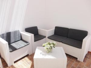 托雷圣乔万尼乌Appartamenti Carneo Torre San Giovanni - Verso sud的客厅配有两把椅子、一张沙发和一张桌子