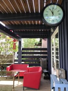 帕维洛斯塔Cardinalis house的露台上的时钟,配有红色的椅子和桌子