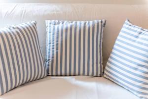 切塔尔多Appartamento nella Campagna di Certaldo Il Ciliegio的白色沙发上的三个蓝色和白色枕头