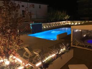里米尼米兰聂斯酒店的后院,晚上设有游泳池