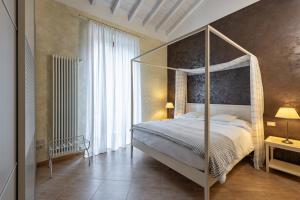 维罗纳玛斯缇诺酒店的一间卧室设有一张天蓬床和大窗户