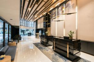 曼谷The Key Premier Hotel Sukhumvit Bangkok的大厅,在大楼里设有沙发和桌子