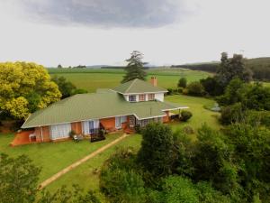 香槟谷Little Acres Drakensberg Accommodation的享有绿色屋顶房屋的空中景致