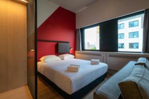 阿姆斯特丹Via Suites的一间卧室设有一张大床和红色的墙壁
