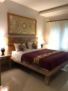 乌布巴厘岛贝图图别墅旅馆的一间卧室配有一张大床和木制床头板