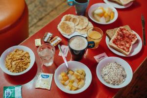 伦敦可林克78旅舍的红色的桌子上放着一碗早餐食品