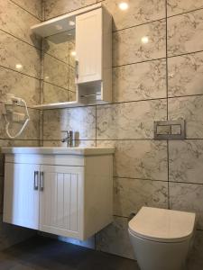 阿德拉桑阿德拉桑艾达酒店的浴室配有白色水槽和卫生间。
