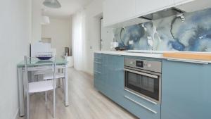 莫尔特拉肖La Terrazza di Casarico的厨房配有蓝色橱柜和玻璃桌