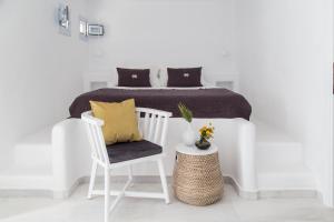 圣玛丽亚The Sand Collection Villas的白色卧室配有床和椅子