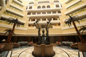 维沙卡帕特南Welcomhotel by ITC Hotels, Devee Grand Bay, Visakhapatnam的棕榈树和雕像的酒店大堂