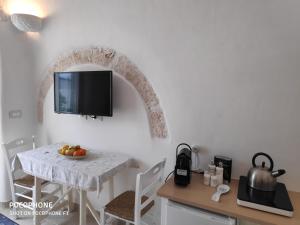 阿尔贝罗贝洛Dimora Sumerano的厨房配有桌子,墙上配有电视。