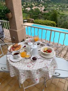 塞扬Villa Magnolia的阳台上的桌子上摆着早餐食品和饮料