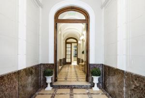 布宜诺斯艾利斯Patios de Recoleta的建筑的走廊,有门和两个花瓶
