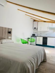 马德里Hotel Madrid Río的卧室配有白色的床和绿色椅子