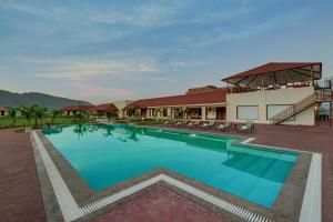 VijayanagarThe Fern Sattva Resort - Polo Forest的大楼前的大型游泳池