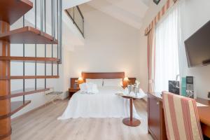 安道尔城Hotel Spa Termes Carlemany的白色卧室配有带白色枕头的床