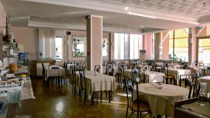 莱圭利亚Hotel Delfino的餐厅配有桌椅和白色桌布