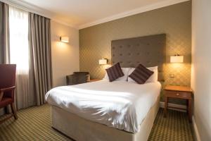 贝辛斯托克经典英国阿波罗酒店的酒店客房带一张大床和一把椅子