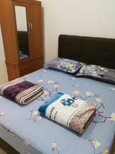 古晋Address No 915, Lorong Uni Central 13, Taman Uni Central, Kuching Samarahan Expressway的一张床上,床上有鲜花,有蓝色的毯子