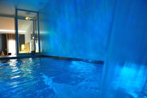 巴塞罗那巴塞罗那加乌丁特套房酒店的室内的蓝色海水游泳池