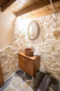 罗德镇Athina house的石墙浴室设有木制水槽和镜子