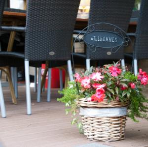 梅灵Hotel Zum Fährturm的坐在桌椅上的一篮鲜花