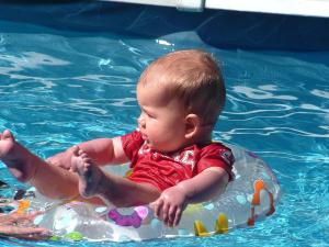 纳尔逊箭公寓汽车旅馆的在游泳池里的一个水中的一个婴儿