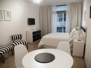 布宜诺斯艾利斯Studio Esmeralda的卧室配有一张床和一张桌子及椅子