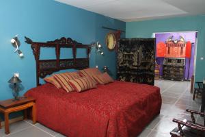 阿尔勒拉夏贝尔农舍酒店的一间卧室设有红色的床和蓝色的墙壁