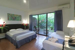 萨拉皮基Tirimbina Rainforest Lodge的酒店客房设有两张床和一个阳台。