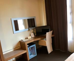 博洛尼亚HC3酒店的客房设有一张带电脑和镜子的书桌