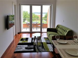 梅杜林Apartments Aurora near beach的客厅配有绿色沙发和桌子