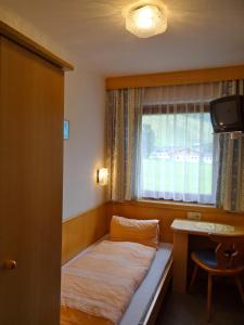 萨尔巴赫玛丽亚滑雪和自行车膳食公寓的一个小房间,窗户前设有一张床