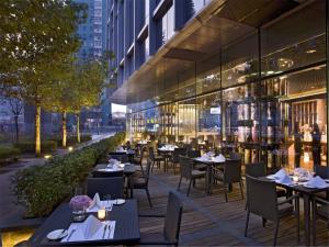 北京北京千禧大酒店的一个带桌椅的室外餐厅,以及一座建筑